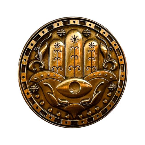 Close up of the Mystical Power Coin showing the Hand of Hamsa symbol, representing protection and spiritual guidance